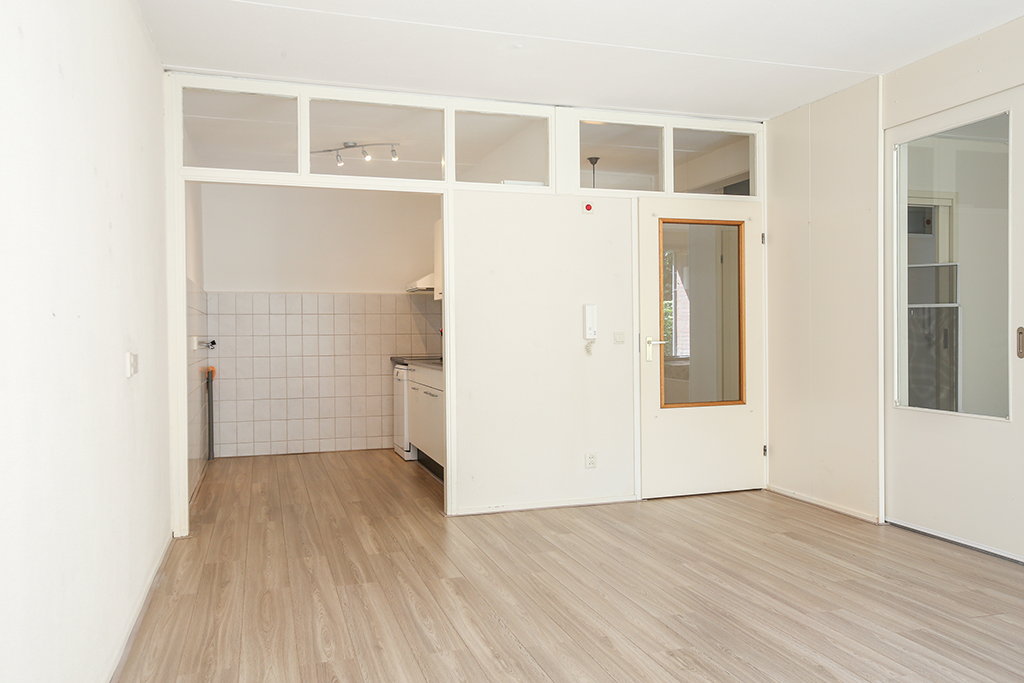 huiskamer met zicht op de keuken en deur naar de hal